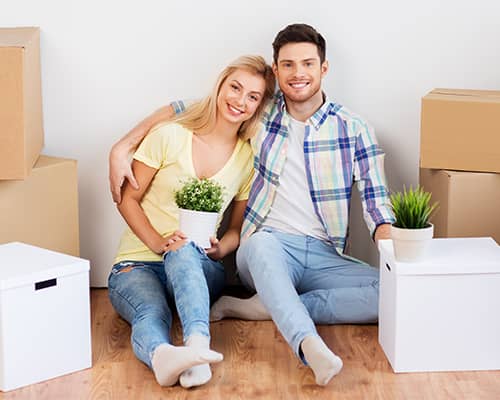 Happy couple with boxes moving to their new home